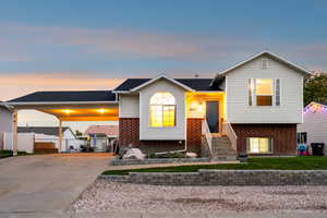 Tri-level home featuring brick siding and concrete driveway