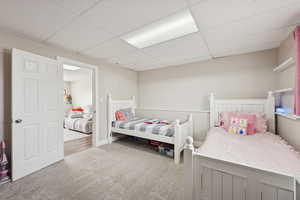 Bedroom featuring carpet floors and a drop ceiling