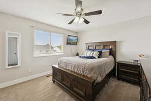 Carpeted bedroom with baseboards and a ceiling fan