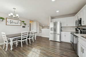 Kitchen featuring stainless steel appliances, white cabinetry, light countertops, dark wood-type flooring, and recessed lighting