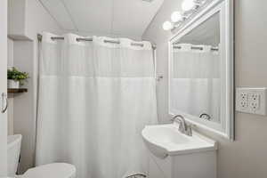 Bathroom featuring vanity, a drop ceiling, and curtained shower