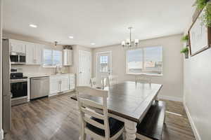 Dining room featuring dark wood-type flooring, a chandelier, and recessed lighting