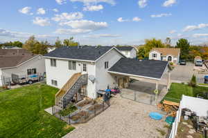 Back of property featuring a shingled roof, a residential view, a gate, stairway, and a patio