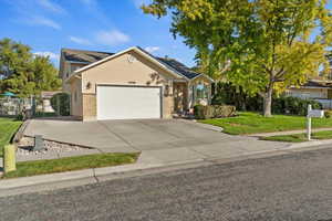 View of front of home with concrete driveway, an attached garage, and brick siding