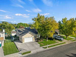 View of front of house featuring driveway, a garage, roof with shingles, a gate, and brick siding