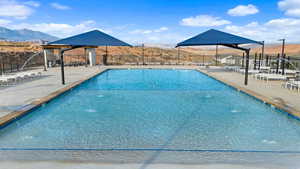 Community pool featuring a mountain view and a patio area