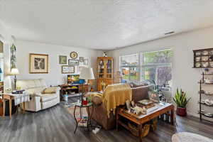 Unit 2 Living room with a textured ceiling and dark wood-type flooring