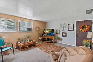 Unit 3 Carpeted living room featuring a textured ceiling and baseboards