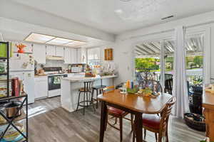 Unit 2 Dining room featuring light wood finished floors and a textured ceiling