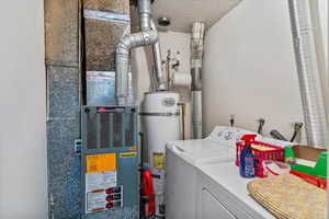 Unit 2 Laundry area with strapped water heater, a textured ceiling, heating unit, and independent washer and dryer