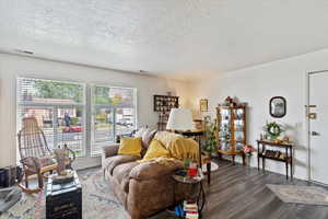 Unit 2 Living area with a textured ceiling and dark wood-type flooring