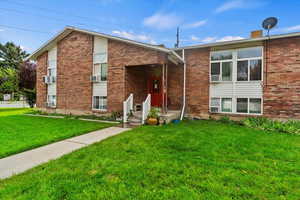 View of front of house featuring a front yard and brick siding