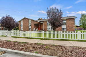 View of front of home with brick siding and a fenced front yard