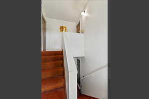 Staircase featuring wood finished floors
