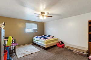Unit 4 Carpeted bedroom with a textured ceiling and ceiling fan