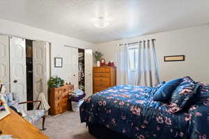 Unit 3 Bedroom with light carpet, a closet, and a textured ceiling