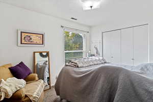 Unit 2 Carpeted bedroom featuring a textured ceiling and a closet