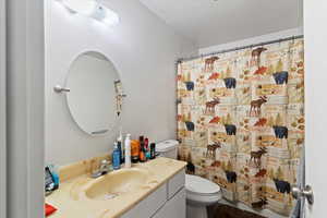 Unit 1 Full bathroom featuring vanity, a textured ceiling, and curtained shower