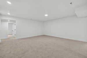 Spare room with light carpet and recessed lighting