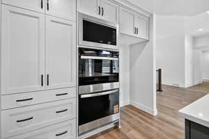 Kitchen with appliances with stainless steel finishes, light wood-style floors, recessed lighting, and white cabinetry
