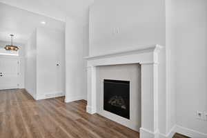 Unfurnished living room featuring a fireplace, wood finished floors, and recessed lighting