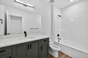 Bathroom with vanity, shower / bath combination, light wood-type flooring, and recessed lighting