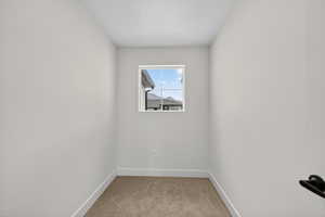 Unfurnished room with light colored carpet and baseboards
