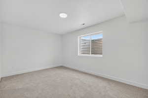 Unfurnished room featuring light colored carpet and baseboards