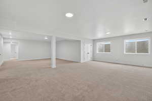 Below grade area with light colored carpet and recessed lighting