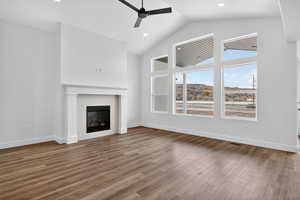 Unfurnished living room with high vaulted ceiling, light wood-style flooring, a fireplace, a ceiling fan, and recessed lighting