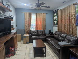 Living room featuring light tile patterned floors, ceiling fan, and recessed lighting