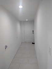 Hall with light tile patterned floors and recessed lighting