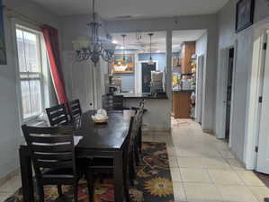Dining space featuring light tile patterned floors and a chandelier