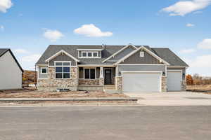 Craftsman house with stone siding, a shingled roof, board and batten siding, driveway, and a porch