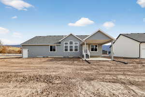Back of house with a patio area and roof with shingles