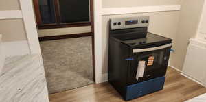 Kitchen view of stainless steel range with electric cooktop and light wood-style flooring
