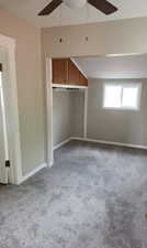 Unfurnished bedroom featuring light colored carpet, a ceiling fan, and a closet