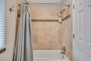 Bathroom with shower / bathtub combination with curtain