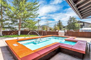 View of pool with a fenced backyard, an outdoor hot tub, a patio area, and area for grilling