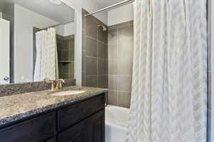 Bathroom with shower / bath combination with curtain and vanity