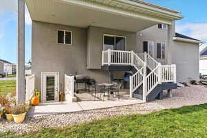 Back of house with a patio area, stucco siding, and a lawn