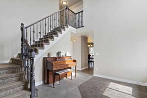 Stairway featuring a towering ceiling and tile patterned flooring