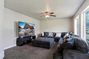 Living area featuring carpet flooring and ceiling fan