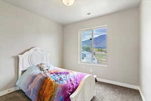 Carpeted bedroom with baseboards and a mountain view