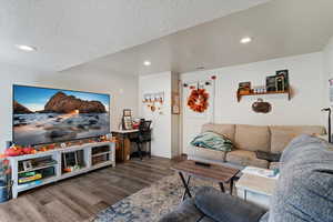 Basement Living area featuring recessed lighting, wood finished floors, and a textured ceiling