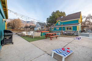 View of patio / terrace with a grill, a hot tub, a mountain view, and a residential view