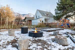 Yard covered in snow with a playground and a mountain view