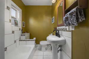 Bathroom with light tile patterned flooring and a bath