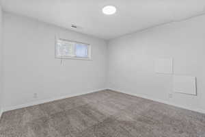 Carpeted spare room with baseboards