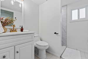Full bathroom featuring vanity, light tile patterned floors, and a tile shower